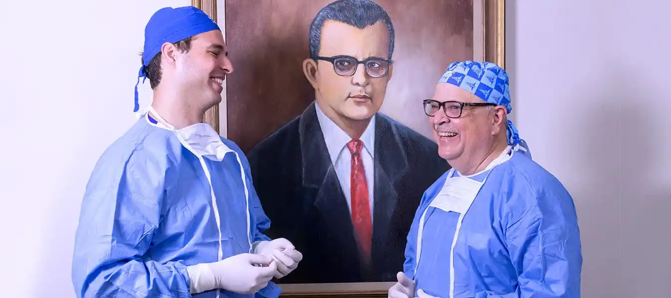 Three generations of Centro Láser ophthalmologists, beside the portrait of founder Dr. Oscar R. Batlle Morel